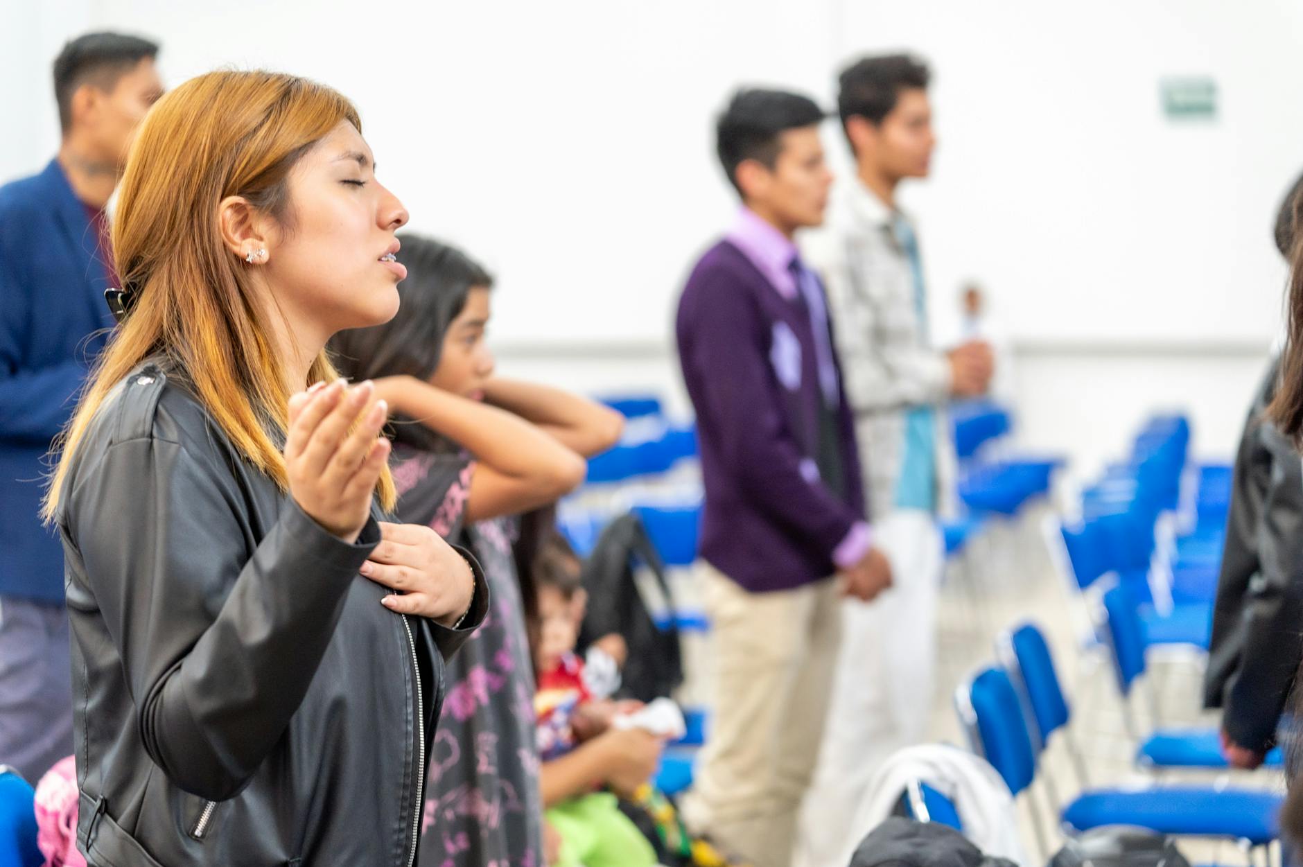 Jak odnaleźć Boga w codziennym zabieganiu: proste praktyki wiary dla zapracowanych chrześcijan Grupa zróżnicowanych osób modli się wspólnie w sali w Ciudad de México